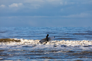 surfer walking in waves - 664470662