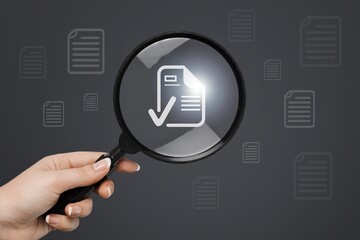 Businessman holding magnifying glass with document icon