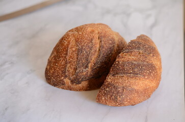 Freshly baked pretty loaf of homemade delicious sourdough bread sliced open on table/counter 