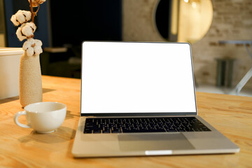 Open laptop with white mockup screen on wooden table on room background. The concept of remote...