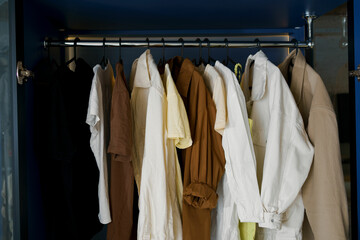 Close-up of clothes hanging on black hangers hanging in the dressing room. The concept of storing...