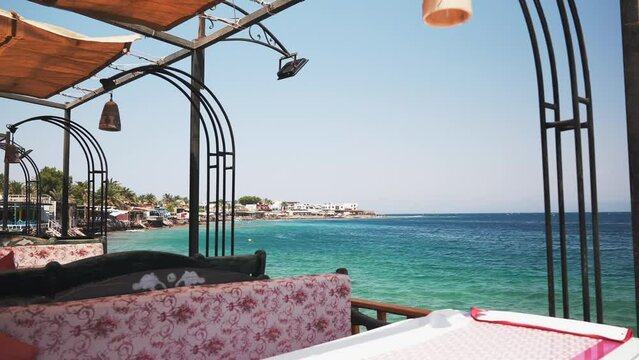 View from the balcony terrace of a beach restaurant to Dahab city embankment at day