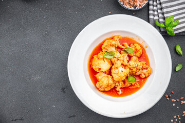 cauliflower in tomato sauce stewed vegetable second course healthy eating appetizer meal food snack on the table copy space food background rustic top view keto or paleo diet vegetarian vegan 