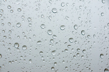 Liquid purity: the delicacy of droplets on white glass.