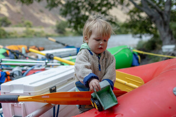 A young boy plays in a raft during a family rafting trip down the Deschutes River in Oregon.