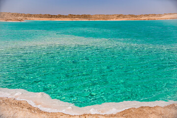 Salt lake with turquoise water and white salt on the shore near Siwa oasis, Egypt - obrazy, fototapety, plakaty