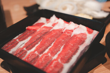 Close up many beef slices in black tray on table. Food for hotpot