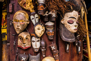 Traditional wooden Zanzibar masks expressing different emotions in the souvenir shop for sale, Stone Town, Tanzania. Tanzanian souvenirs at Zanzibar. - obrazy, fototapety, plakaty
