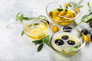 Olive oil in a bottle on texture background. Oil bottle with branches and fruits of olives. Place...