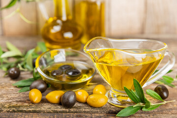 Olive oil in a bottle on texture background. Oil bottle with branches and fruits of olives. Place...