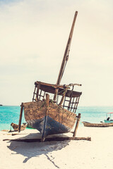 Beautiful Zanzibar coast line. Wooden fisherman boats on sandy beach with blue water background, Zanzibar, Tanzania