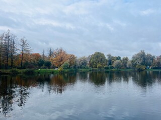 Fototapeta na wymiar autumn trees reflection on the pond surface in the park