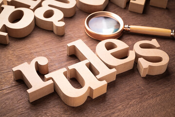 Rules word by thick wooden alphabets with magnifying glass, know the rules concept