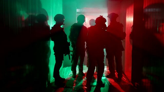 military tactical team with leader preparing to assault of building seized by terrorists, silhouette