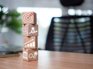 Wooden blocks and business icons on table wood represent the concept of business strategy and...
