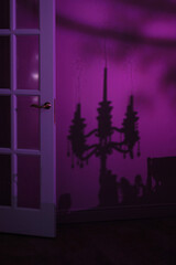 Dark and mysterious interior with chandelier silhouette on purple wall. Concept for creating a dramatic mood or atmosphere in your design project or artwork.Copy space available for your text or logo.