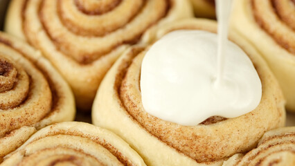 Pouring cream on cinnamon rolls