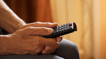 Elderly man's hands with remote control doo tv. Elderly man's hand with remote control doo tv Channel