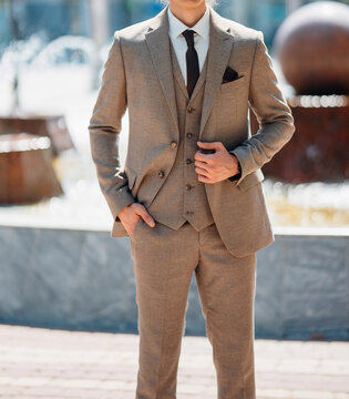 without a face. A man in a light-colored three-piece suit.