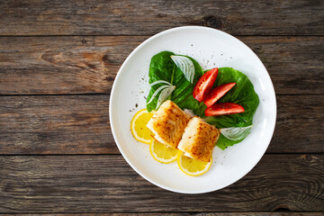 Seared cod loin and fresh vegetables on wooden table
 - obrazy, fototapety, plakaty