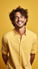 Fototapeta na wymiar Sunny smile in Butter Yellow. Handsome model with a bright, sunlit smile against a butter yellow backdrop. Vertical orientation. 