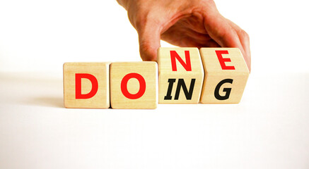 Doing and done symbol. Concept words Doing Done on wooden block. Beautiful white table white background. Businessman hand. Business doing and done concept. Copy space. © Dzmitry