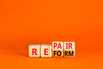 Reform and repair symbol. Concept words Reform Repair on wooden block. Beautiful orange table...
