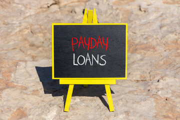 Payday loans symbol. Concept words Payday loans on beautiful black chalk blackboard on a beautiful...