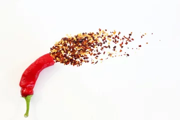 Cercles muraux Piments forts hot red chili pepper with chili flakes burst in white background as food background,top view with copy space