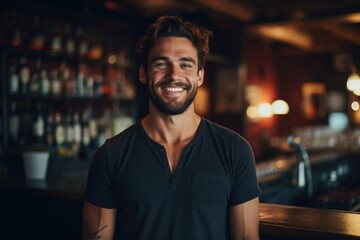 Fototapeta na wymiar Portrait of a smiling young waiter in a bar