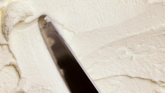 Knife mowing on organic, delicious, fresh, humanmade melted butter. Dairy products. Healthy eating. Concept of texture of food, taste, organic products