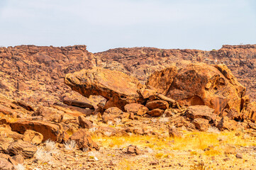 A view of large boulders and eroded sandstone rock in Twyfelfontein in Namibia during the dry season