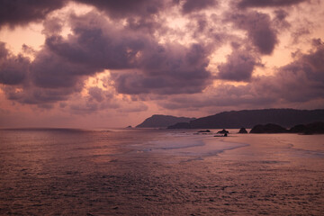 Naklejka na ściany i meble Massive Clouds, Reddish Sea, and Sunset Waves in Lombok's Majestic Serenity