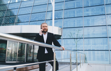 Serious businessman chatting on smartphone