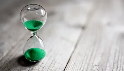 Foto op Canvas Hourglass with green sand time passing background concept for business deadline, urgency and running out of time © Brian Jackson
