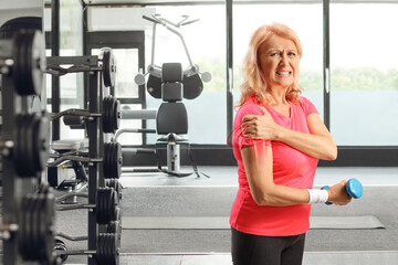 Woman with injured shoulder holding a dumbbell