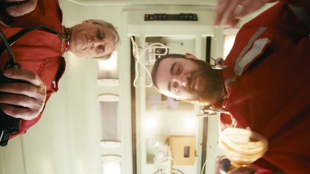First person. The patient sees several health care workers checking their breathing and putting on a breathing mask. Carrying out first medical aid to the patient. Resuscitation, first aid, medicine.