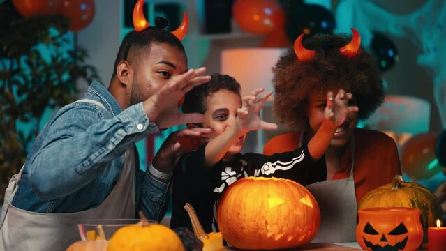Happy African American family in Halloween costumes posing for video story, fun