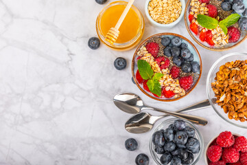 Bowl of granola with yogurt and fresh berries on a texture table. Yogurt berries, acai bowl, spirulina bowl. Healthy food, balanced breakfast. Strawberries, blueberries, kiwi, peach, almonds and chia.