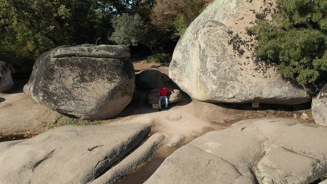 Drone view of a man sitting at Begliktash which is an ancient ruin near the city of Primorsko, Bulgaria. Beglik Tash is a prehistoric rock phenomenon located on the southern coast of the Black Sea.