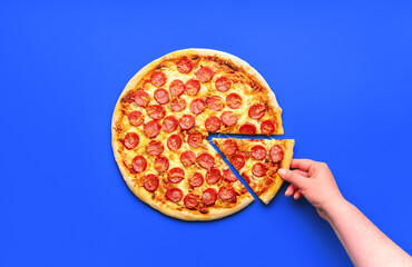 Homemade pizza pepperoni isolated on a blue background
