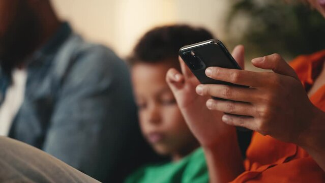 African American family scrolling smartphones, ignoring each other, gadgets