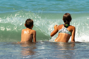 Children in the sea before the wave