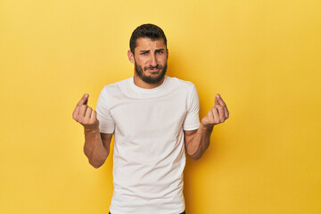 Young Hispanic man on yellow background showing that she has no money.