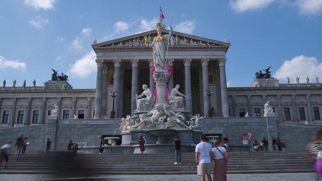 Unrecognizable people in front of the parliament building in Vienna, Austria, built in 1883 with a greek revival style architecture. Day timelapse, sightseeing, tourist attraction, landmark.