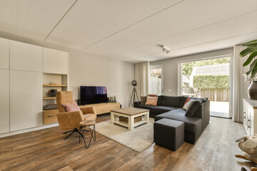 Fototapeta premium a living room with wood flooring and white cabinetd doors leading to the patio area, which is open