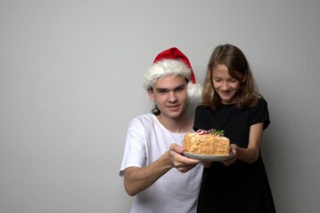  Brother and sister holding Christmas sweet treat cake in their hands, isolated, copy space