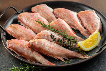 Raw fish perch with lemon, rosemary, salt on a dark background. banner, menu, recipe place for text, top view