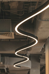 modern LED lighting by curved lamp in industrial interior. Ceiling in an industrial space with...