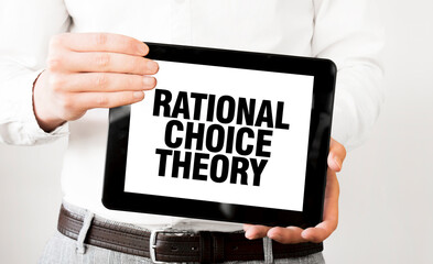 Text RATIONAL CHOICE THEORY on tablet display in businessman hands on the white background. Business concept